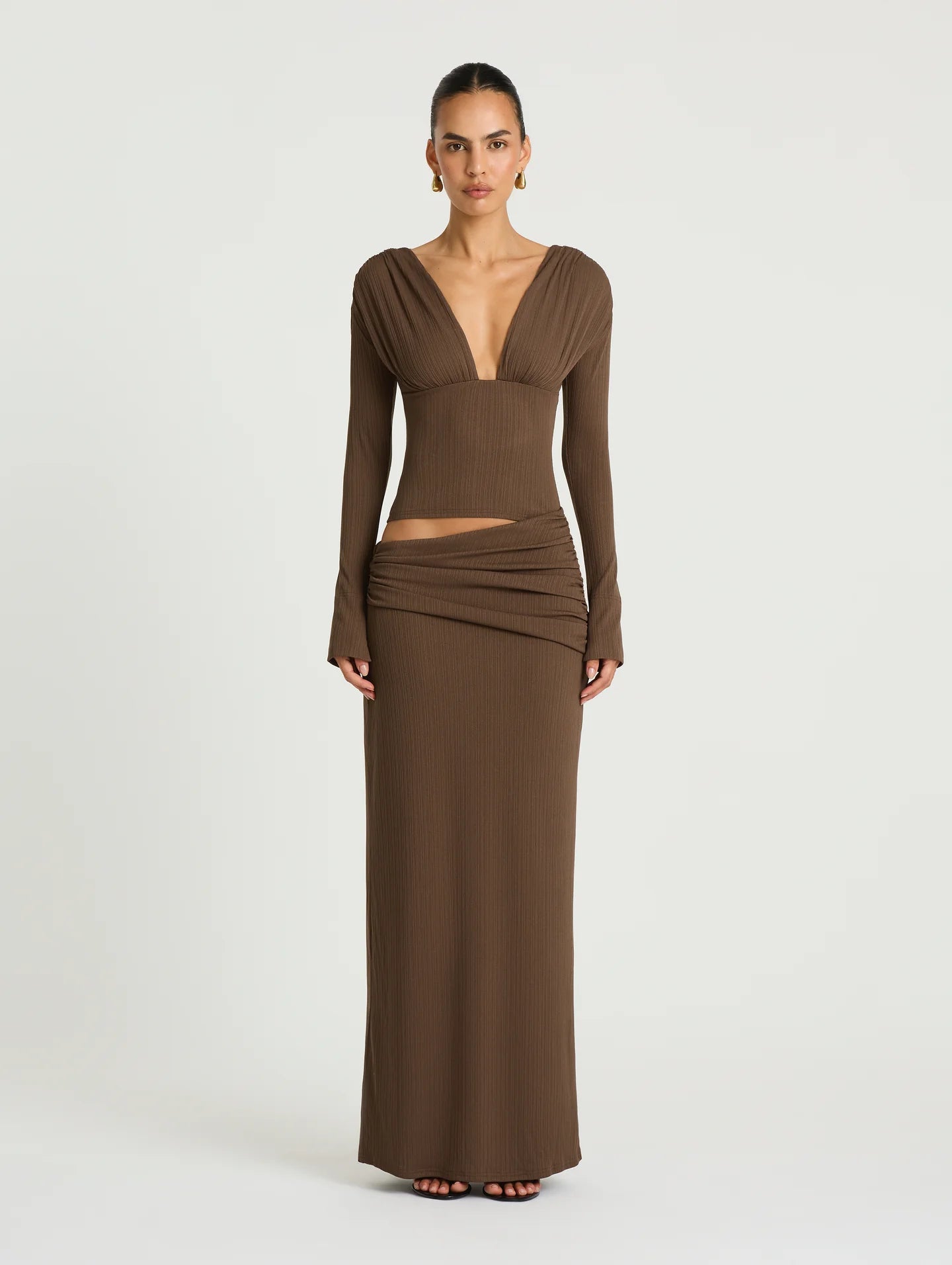 Woman wearing a brown long-sleeve dress on a white background