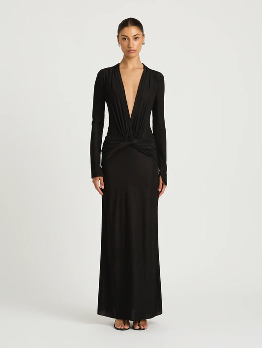 A model wearing a long-sleeved black maxi dress with a plunging V-neckline.