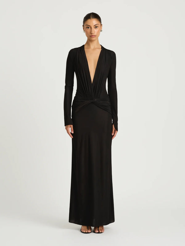 A model wearing a long-sleeved black maxi dress with a plunging V-neckline.