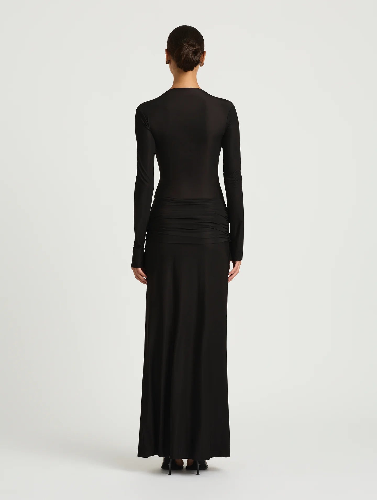 Black long-sleeve dress worn by a model on a white background