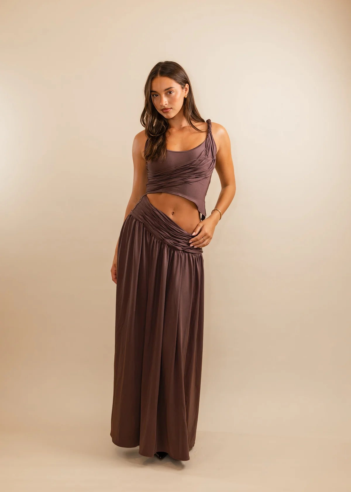 Woman wearing a long, flowing dress against a beige background