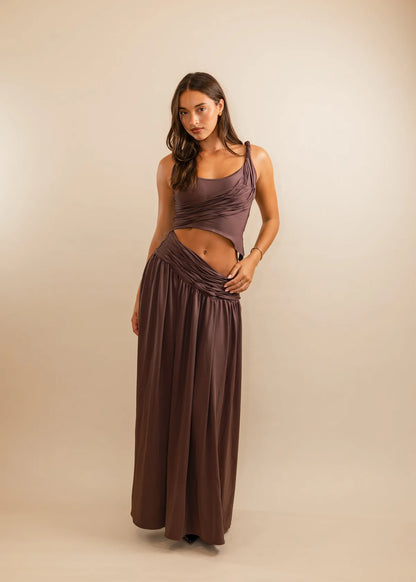 Woman wearing a long, flowing dress against a beige background