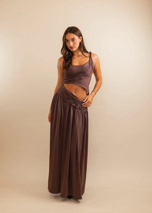 Woman wearing a long, flowing dress against a beige background
