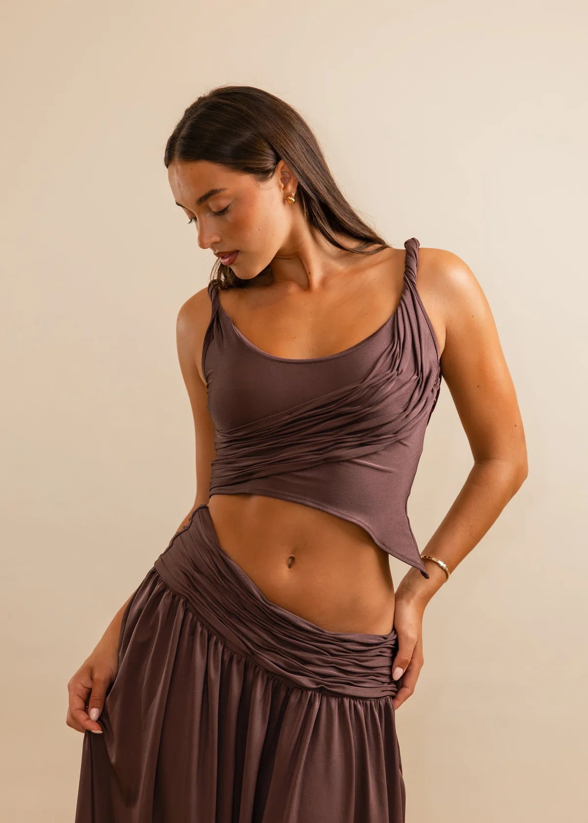 Woman wearing a brown dress against a beige background