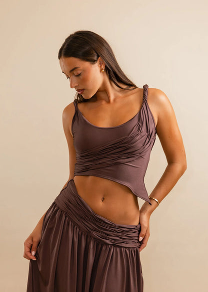 Woman wearing a brown dress against a beige background