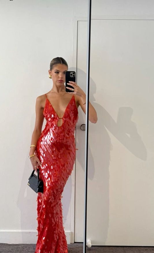 Person wearing a red sequin dress taking a mirror selfie.