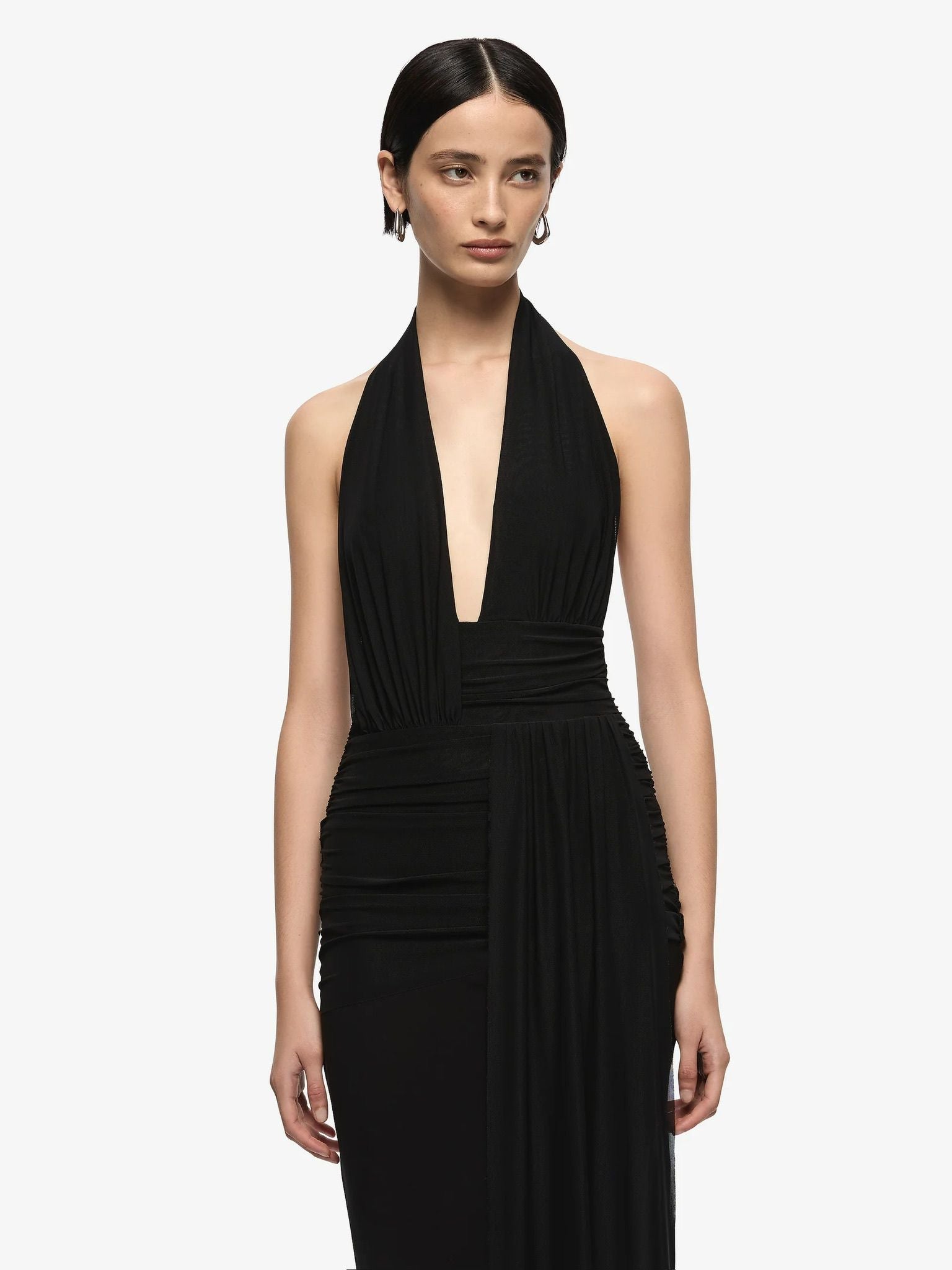 Woman wearing a black halter neck dress on a white background
