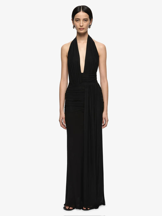 Woman wearing a black halter neck gown on a white background